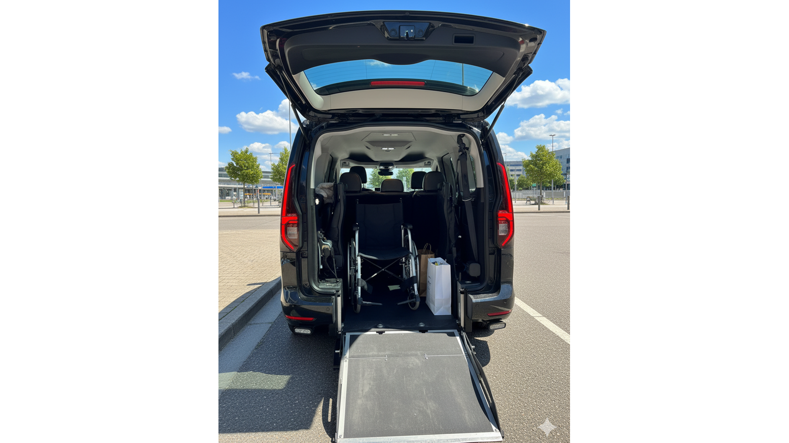 Taksi Wallin Oy:n esteet&ouml;n invataksi, jossa on avoinna takaluukku ja ulosvedetty luiska py&ouml;r&auml;tuolin lastaamista varten. Auton sis&auml;ll&auml; on py&ouml;r&auml;tuoli.